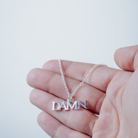 Silver-plated DAMN Necklace – worn on hand | Above Average